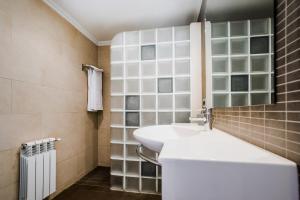 a bathroom with a white sink and a mirror at Hotel El Cid in Morella