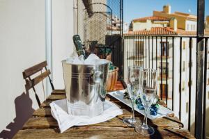 a table with a bucket and wine glasses on a balcony at Hotel El Cid in Morella