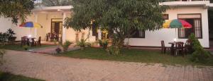 a patio with tables and umbrellas in front of a house at Miheen Hotel & Resort - Anuradhapura in Mihintale