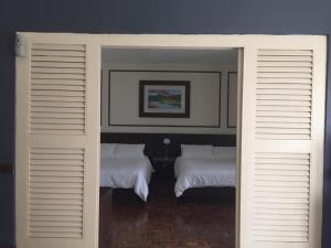 two beds in a room with two white beds at D savoy @ Famosa by MR in Melaka