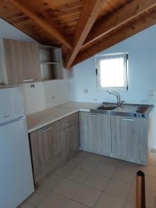 a kitchen with wooden cabinets and a sink and a window at ΑRILLA STUDIOS in Perdika