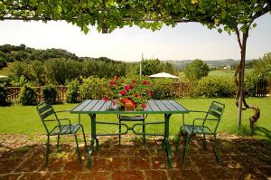 a picnic table with flowers and chairs in a yard at Agriturismo La Mela in Collevalenza