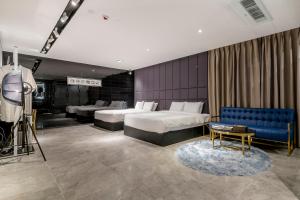 釜山Air Sky Hotel的酒店客房,设有两张床和一张蓝色的沙发