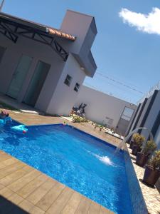 a swimming pool in front of a house at Recanto das Gerais in Passos