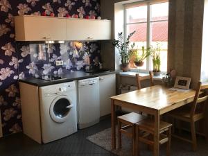 eine Küche mit einer Waschmaschine und einem Tisch in der Unterkunft Hanna's residence in Valmiera