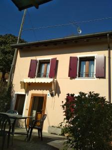 a house with purple shuttered windows and a table at VOLOLIBEROAPARTMENTS 2 in Borso del Grappa