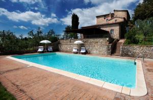 a swimming pool in front of a stone building at Agriturismo Poggio Bonelli in Castelnuovo Berardenga