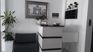 una habitación con una silla y una foto en la pared en Hotel Ceko, en Sarandë
