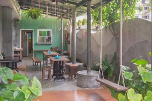 a patio with a table and chairs and plants at Just Fine Krabi in Krabi