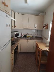 a kitchen with a white refrigerator and a table at Casa amaro in Vejer de la Frontera