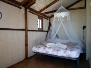 Cama en habitación con mosquitera en Les lodges d'Adelaide, en Cahuzac-sur-Vère