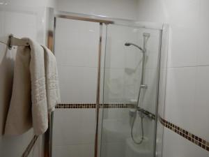 a bathroom with a shower with a glass door at Guesthouse Coimbra City in Coimbra