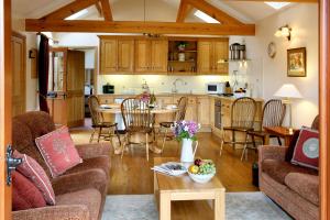 a living room and kitchen with a table and chairs at Arbor Holiday Cottages in Southam