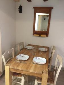 uma mesa de madeira com cadeiras e um espelho na parede em Apartamento Mañueta em Pamplona