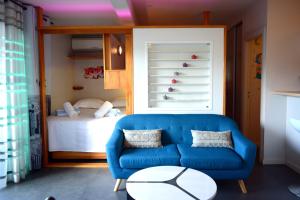 - un salon avec un canapé bleu et un lit dans l'établissement Moana Studio - downtown Papeete - WiFi AC Netflix parking - 3 people, à Papeete