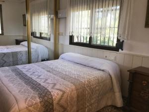 a bedroom with two beds and two windows at "La Chacra" Casa Típica Valenciana in Godella