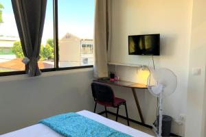 um quarto com uma secretária, uma cama e uma janela em Ery apartment - Papeete downtown - 2 bedrooms - AC - WiFi - 6 pers em Papeete