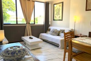 um quarto com uma cama branca e uma mesa e uma mesa sidx sidx em Ery apartment - Papeete downtown - 2 bedrooms - AC - WiFi - 6 pers em Papeete
