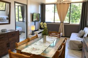 uma sala de estar com uma mesa de jantar e uma sala de estar em Ery apartment - Papeete downtown - 2 bedrooms - AC - WiFi - 6 pers em Papeete