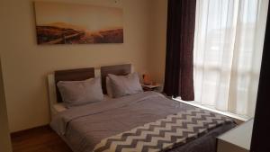 a bedroom with a bed with a large window at Emona Apartment in Burgas