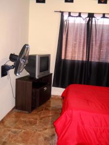 een slaapkamer met een bed, een ventilator en een televisie bij Style Malargue a 100 mtrs del centro,ubicadisimo in Malargüe