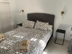 um quarto com uma cama com um edredão preto e branco em Villa Oasis em Puerto del Carmen