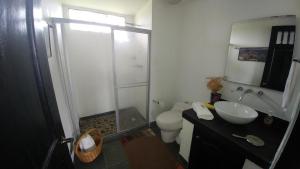 y baño con ducha, aseo y lavamanos. en Santamaría Hotel Bed and Breakfast, en Pereira