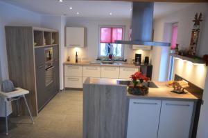 a kitchen with white cabinets and a stove top oven at Eifelgold in Habscheid