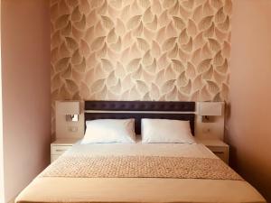 a bedroom with a bed with a wall with feathers at Lovely Apartments D in Patra