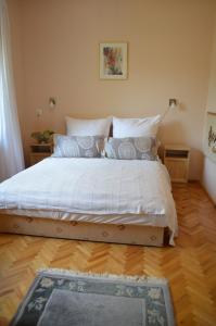 a bed with white sheets and pillows in a bedroom at Magdaléna Holiday Home in Zalakaros