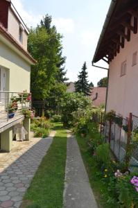 a garden with a walkway next to a house at Magdaléna Holiday Home in Zalakaros