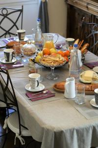 una mesa con un mantel blanco con comida. en Terre d'espérance, en Saint-Aignan
