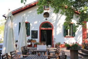 un restaurant avec des tables et des parasols en face d'un bâtiment dans l'établissement Le Valli, à Pellestrina