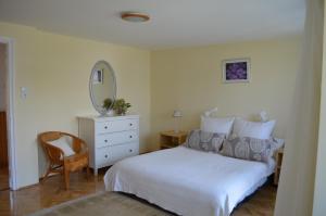 a bedroom with a white bed and a mirror at Magdaléna Holiday Home in Zalakaros