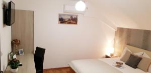 una habitación de hotel con una cama y una foto en la pared en Rooms Velo, en Korenica
