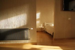 a bedroom with a bed and a television on a wall at LVIV WALL STREET APT in Lviv