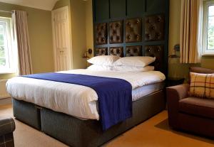 a bedroom with a large bed and a chair at The Carpenters Arms in Pensford