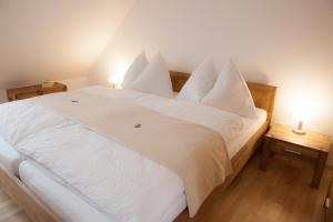 1 dormitorio con 1 cama blanca con sábanas y almohadas blancas en Appartementhaus ECONTO, en Baden