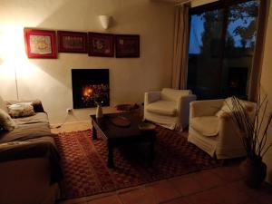 a living room with a couch and chairs and a fireplace at Las Navezuelas in Cazalla de la Sierra