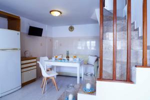 a kitchen with a white table and a white refrigerator at Villa Skiadeni in Halki