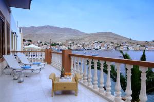 a balcony with chairs and a view of a city at Villa Skiadeni - Sea front house in Halki