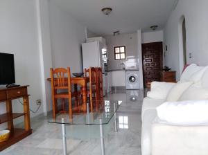 a living room with a glass table and chairs at Apartamento El Faro de Mijas in Mijas Costa