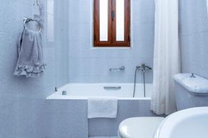a bathroom with a tub and a toilet and a sink at Villa Skiadeni in Halki +18 photos