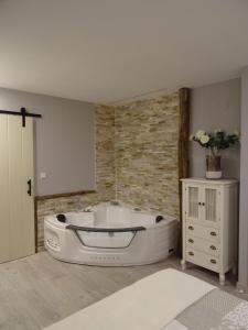 uma banheira branca num quarto com uma parede de tijolos em Apartamento Usuaia con jacuzzi em Lesaka