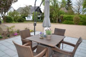 a table and chairs with an umbrella on a patio at Eifelgold in Habscheid