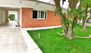 una casa con un albero nel cortile di Casa em Capao a Capão da Canoa