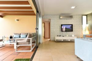 a living room with a couch and a tv on a wall at Salobre Villa with Pool Par 4 nr 9 in Salobre