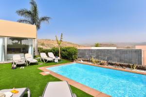 a backyard with a swimming pool and lawnitures at Salobre Villa with Pool Par 4 nr 9 in Salobre
