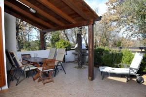 a patio with a wooden pergola and a table and chairs at Holiday House Lena in Poreč