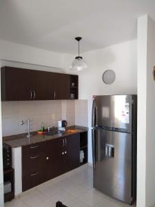 a kitchen with a stainless steel refrigerator and brown cabinets at Estudio centrico en Resistencia in Resistencia